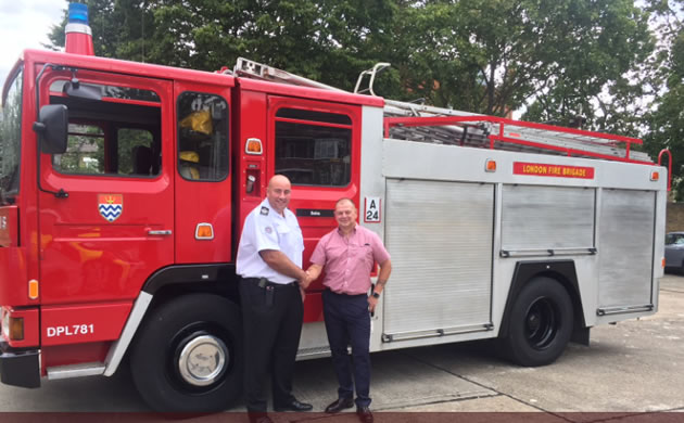 Fire chief congratulates retired fire officer who restored the fire engine 