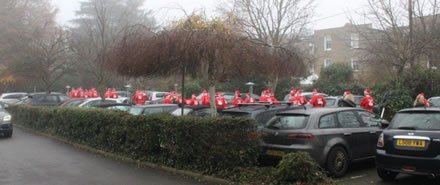image of people dressed as Santa in the car park 