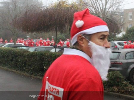 picture of man dressed as Santa while others congregate in the car park 