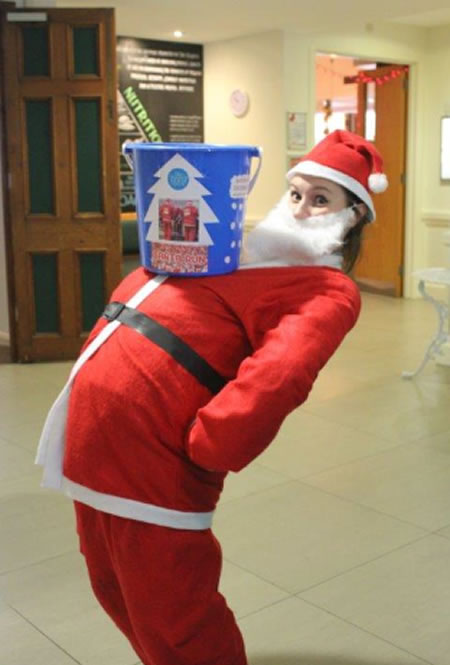 girl dressed as Santa with bucket on her tummy