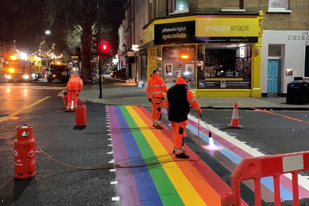 Workmen installing the rainbow crossing on Turnham Green Terrace 