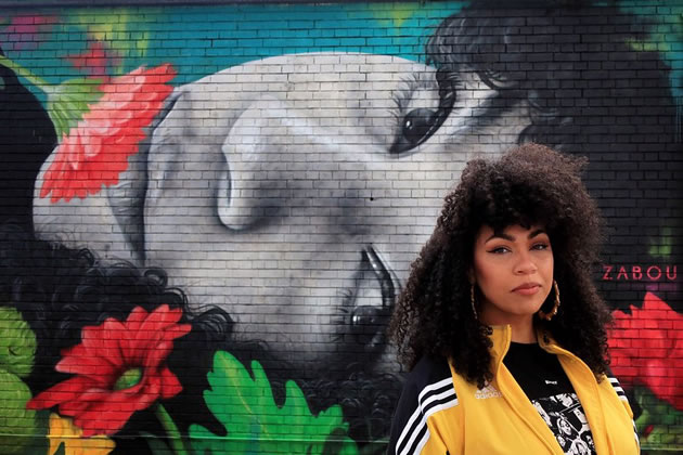 ZABOU in front of her mural featuring Eva Lazarus in Chiswick