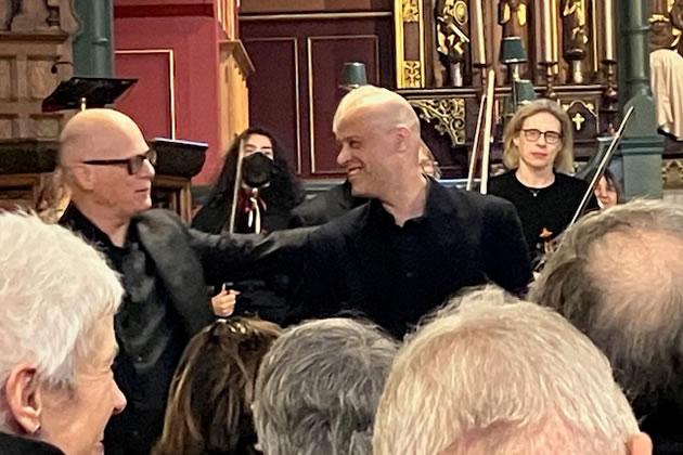 Sandy Burnett and the orchestra's members receive the audience's applause 